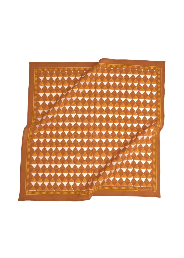 Orange and white patterned fabric bandana laying flat on a white background