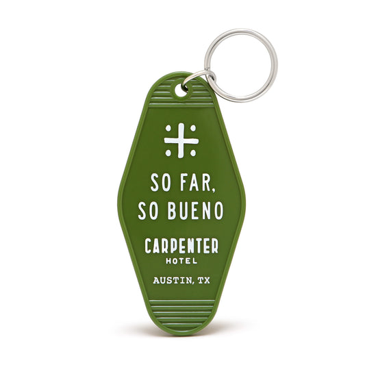 A green vintage-style keychain with white text that reads 'SO FAR, SO BUENO CARPENTER HOTEL AUSTIN, TX'.