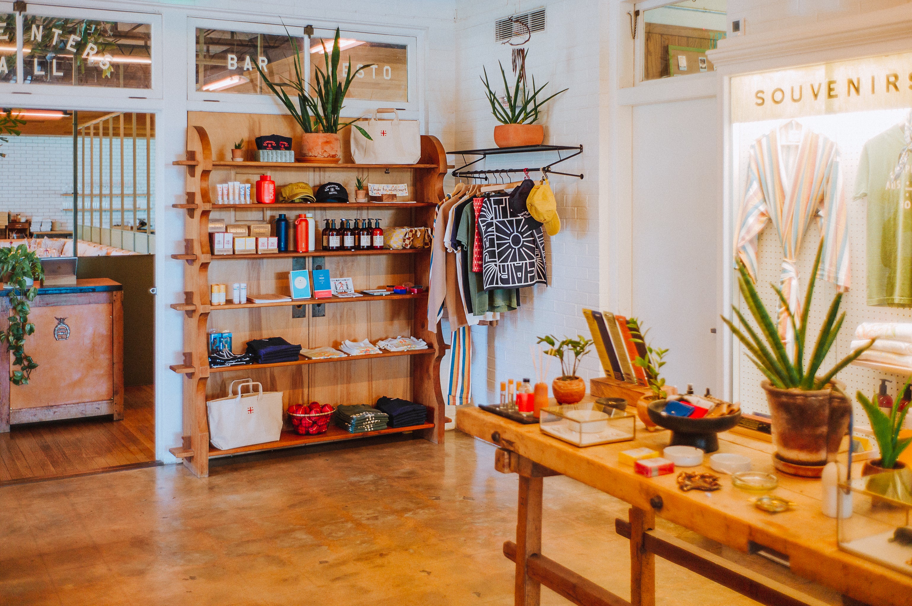Interior of a store with wooden shelves, tables, and various items on display.