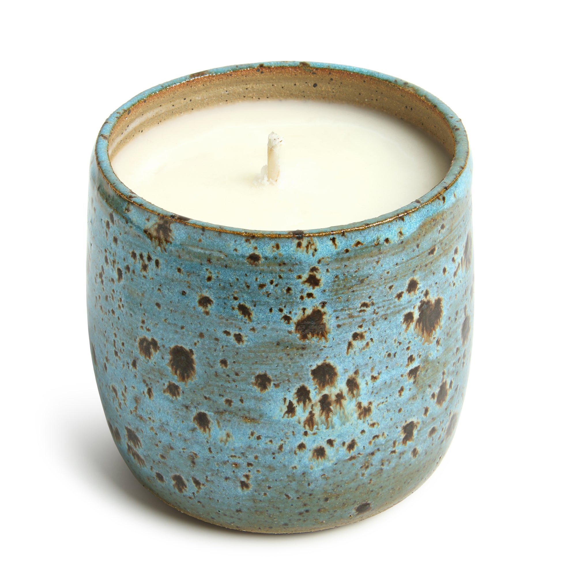A ceramic candle vessel with a blue and brown speckled design with a candle wax insert.