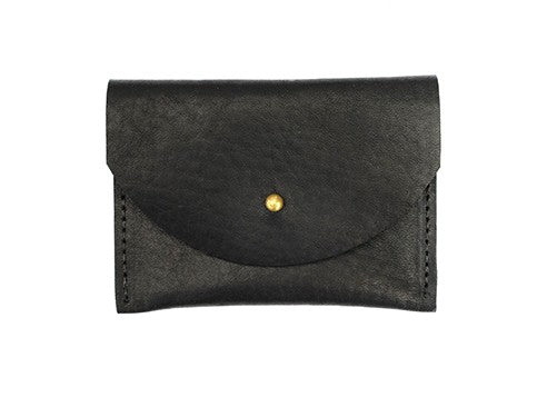 Black leather cardholder with golden colored brass hardware against white background