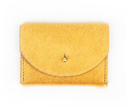Yellow cowhide cardholder with golden colored brass hardware against white background