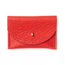 Pebbled leather tomato red cardholder with golden color brass clasp on white background